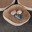 A collection of river stone trays in varying sizes and colors.