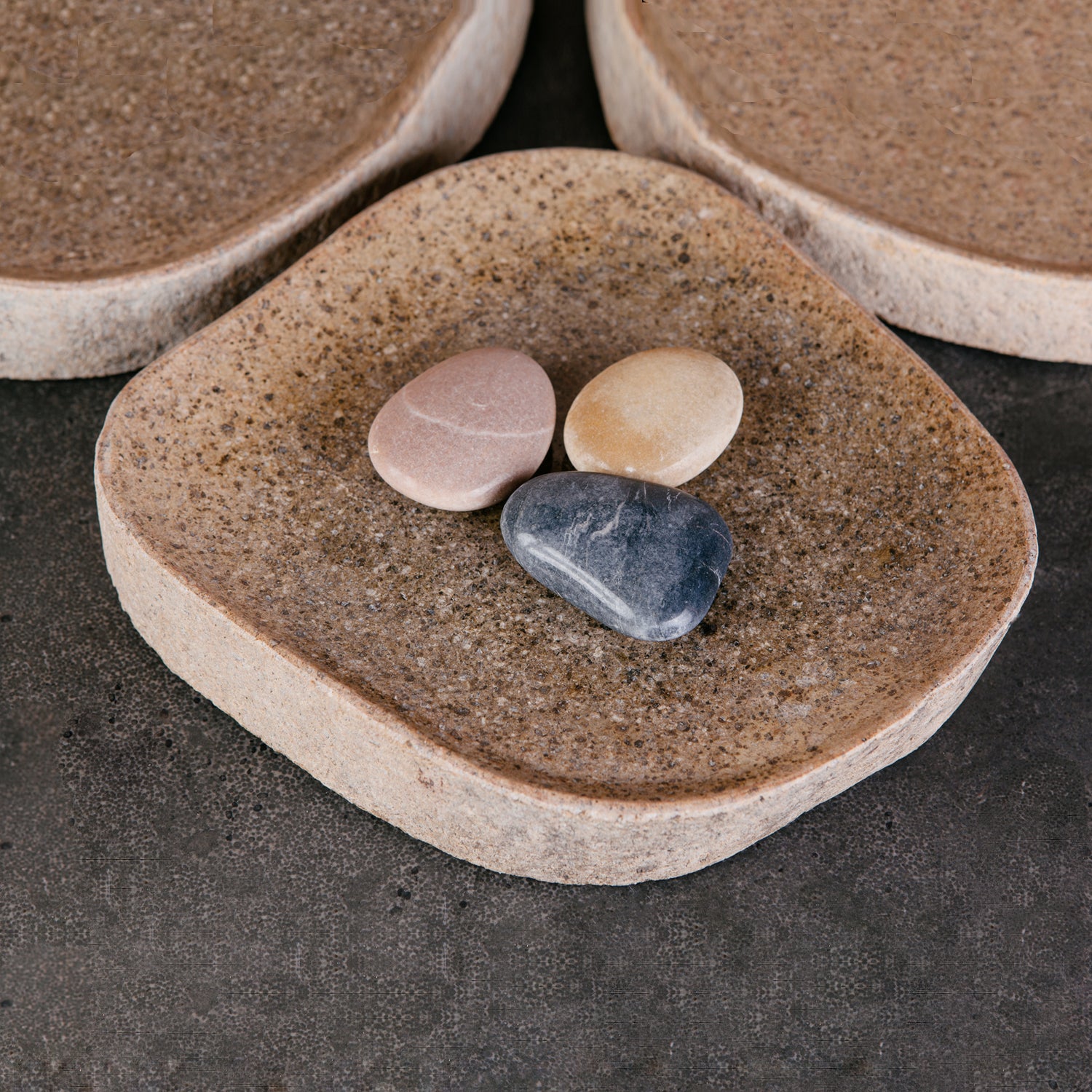 A collection of river stone trays in varying sizes and colors.