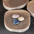 A collection of river stone trays in varying sizes and colors.
