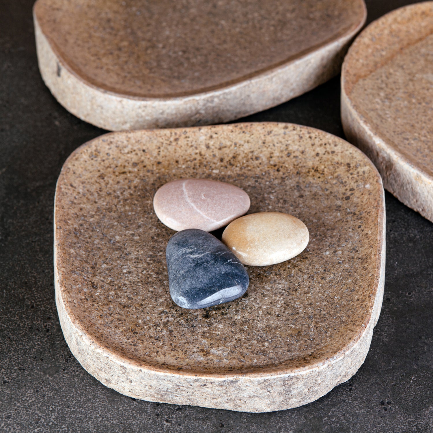 A collection of river stone trays in varying sizes and colors.