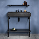 Antique gray limestone trough console with matte black elemental facet trough vanity legs and a metal tray.