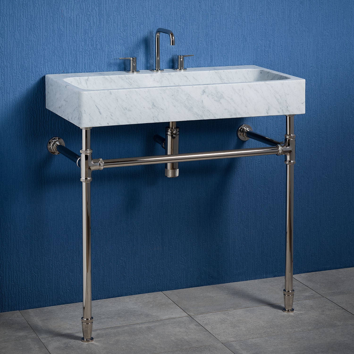 The Trough Console is an integral sink carved from carrara marble features a honed finish.&nbsp;Paired here&nbsp;with an Elemental Facet Trough Vanity w/Crossbar in polished nickel.