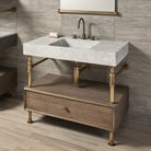 A Carrara marble bath sink on an Elemental Classic Drawer Vanity with an aged brass finish and wood elements.