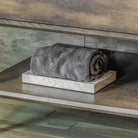 A rectangular Carrara marble bath tray with visible white and gray patterns characteristic of marble stone.