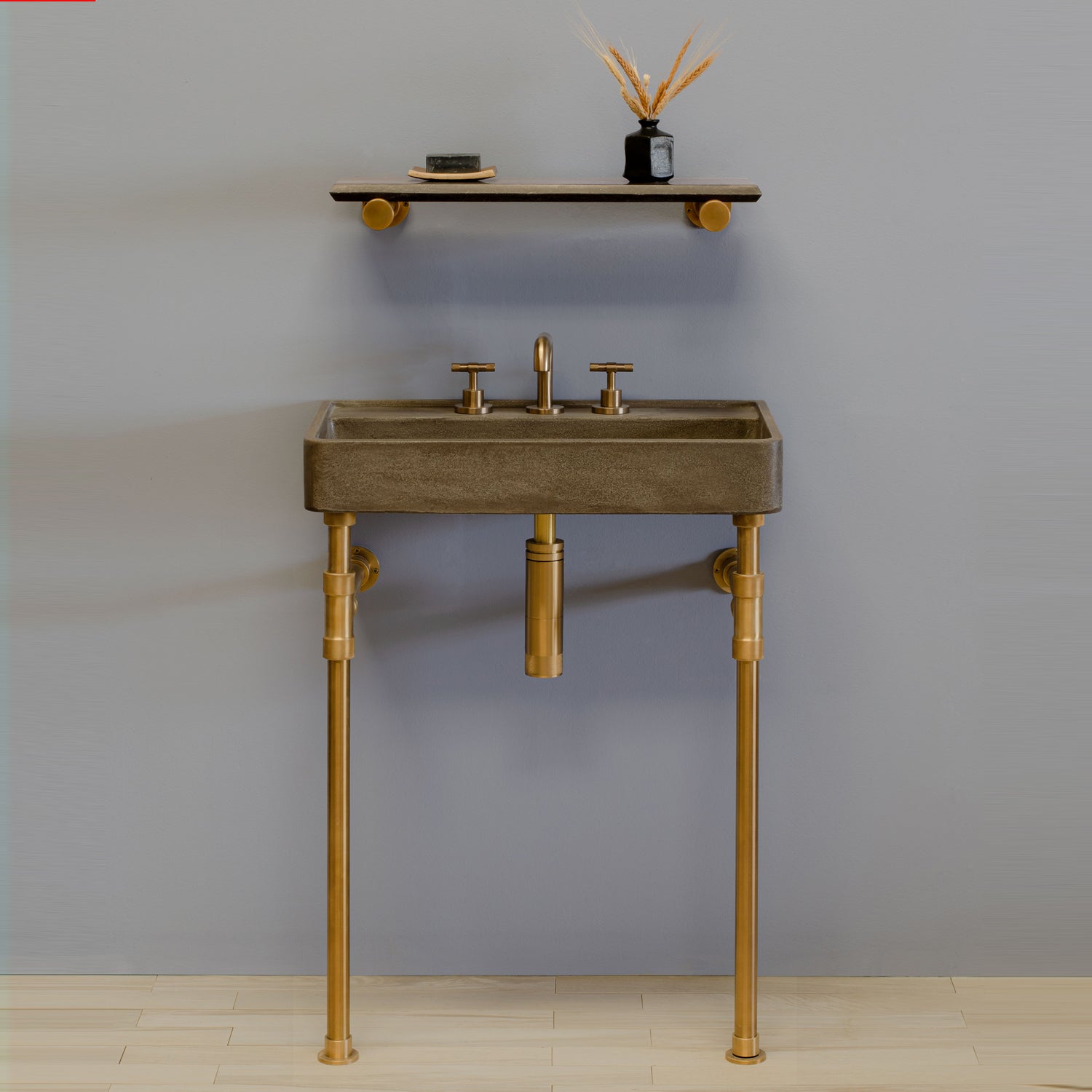 A small concrete Lumbre bath sink on aged brass legs 