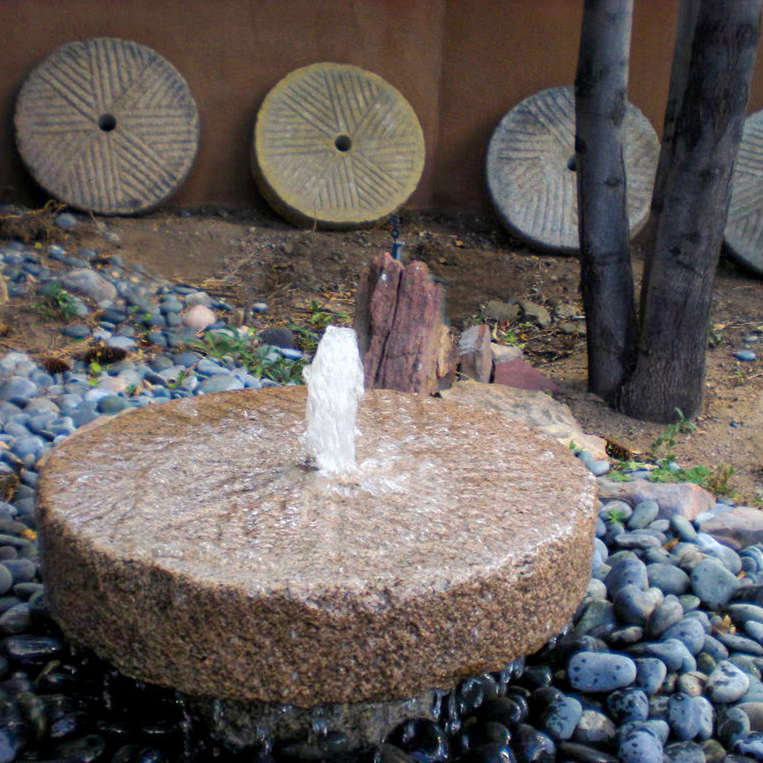 Stone Forest small antique millstone used as a garden fountain