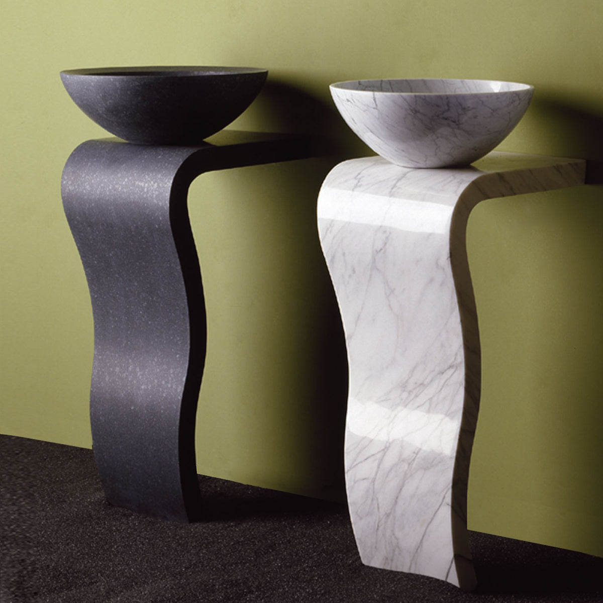 Two Stone Forest Wave Pedestals. One is honed basalt with Beveled Rim Vessel Sink and the other in polished carrara with the Urban Vessel sink. Both carved from a solid block of stone. image 1 of 3